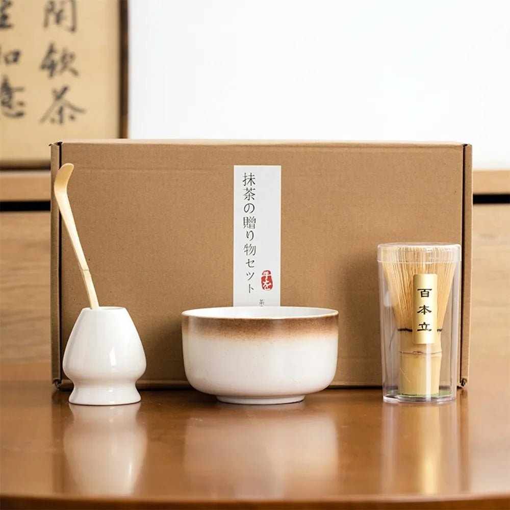 Matcha tea kit with white ceramic bowl bamboo matcha set whisk scoop and whisk holder arranged in front of a gift box