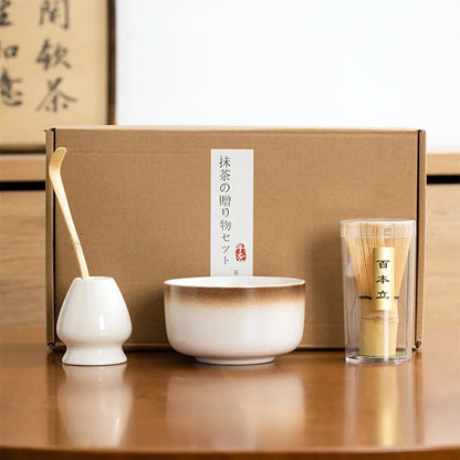 Matcha tea kit with white ceramic bowl bamboo matcha set whisk scoop and whisk holder arranged in front of a gift box