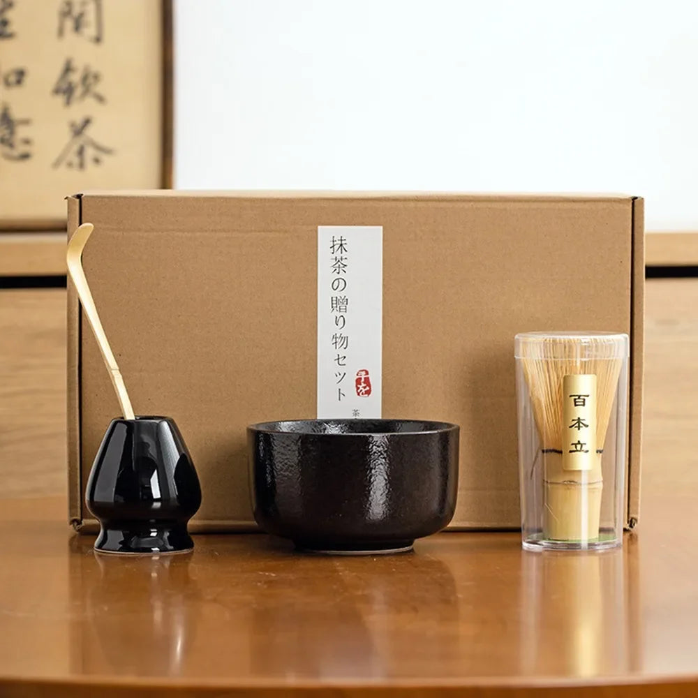 Matcha tea gift set with glossy black ceramic bowl bamboo matcha set whisk scoop and whisk holder in front of a gift box