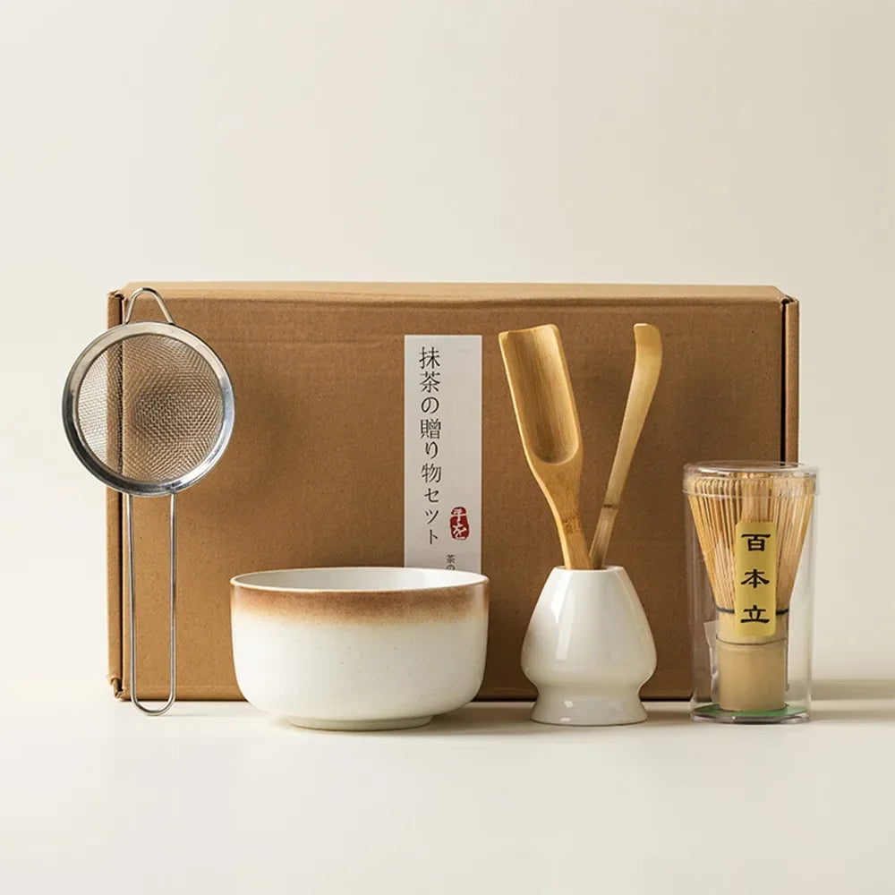 A complete matcha tea kit featuring a bamboo whisk, ceramic bowl, and tools beautifully arranged in a gift-ready box