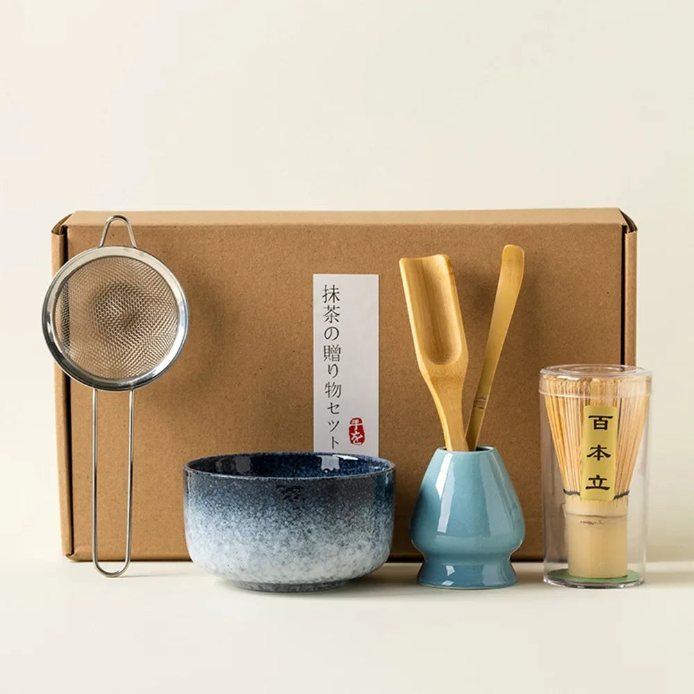 Matcha tea gift set with blue ceramic bowl bamboo whisk scoop strainer and whisk holder arranged in a brown gift box